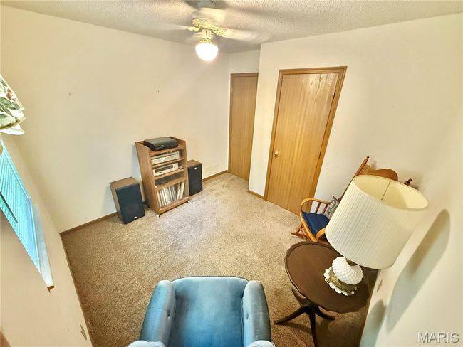Living area with ceiling fan, carpet floors, and a textured ceiling | Image 26