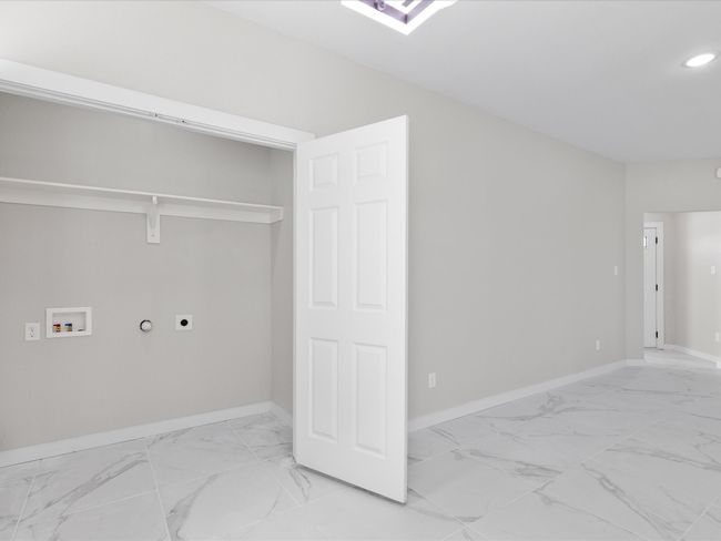 Laundry room with electric dryer hookup, marble finish floor, washer hookup, baseboards, and laundry area | Image 13
