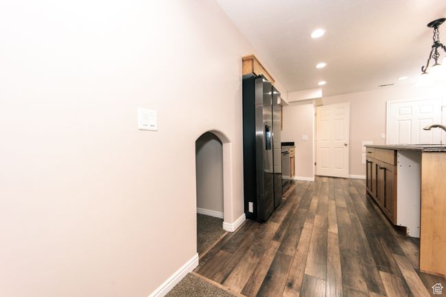Kitchen featuring arched walkways, stainless steel fridge with ice dispenser, (Refrigerator stays) LVP floors, and a fun space to the left for children's play space or extra storage. | Image 28