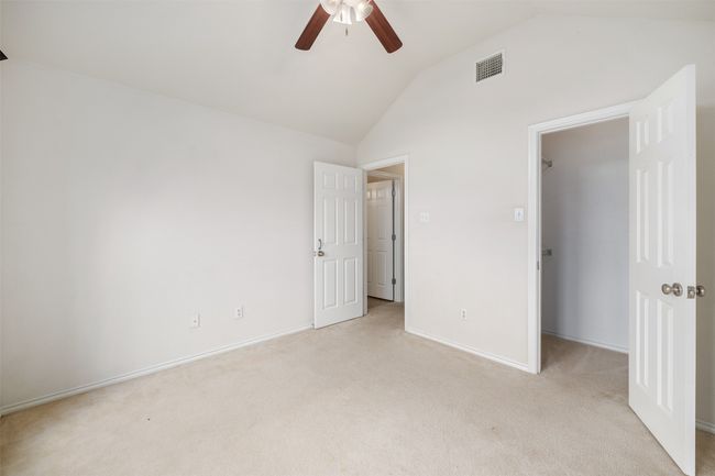 bedroom with light carpet, vaulted ceiling, and a walk in closet | Image 15