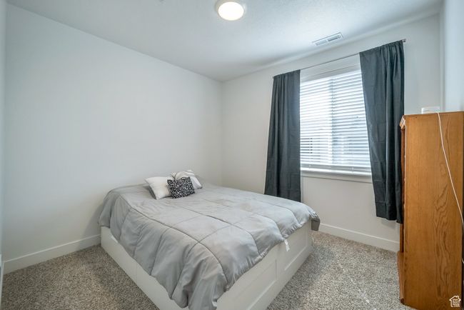 Carpeted bedroom featuring baseboards and visible vents | Image 12