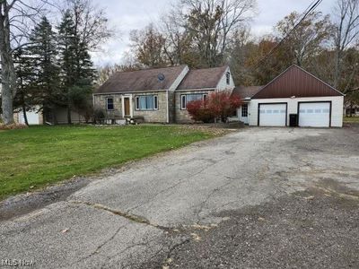 View of front facade with a front yard, an outbuilding, and a garage | Image 1