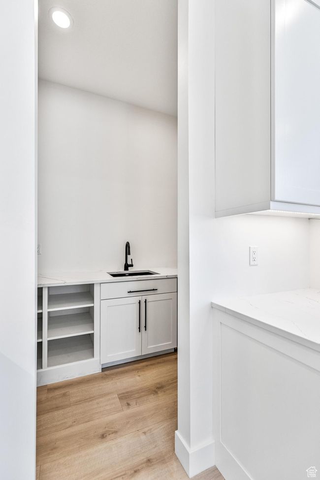 Bar with light wood-style floors, a sink, and recessed lighting | Image 62