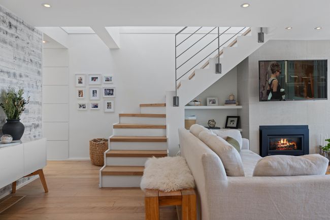 Living area with stairs, wood finished floors, a fireplace, recessed lighting, and built in features | Image 9