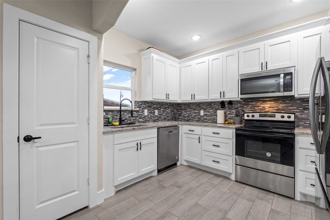 Kitchen featuring appliances with stainless steel finishes, white cabinets, tasteful backsplash, recessed lighting, and light stone​​‌​​​​‌​​‌‌​‌‌​​​‌‌​​‌‌​‌​​​​​‌ countertops | Image 22