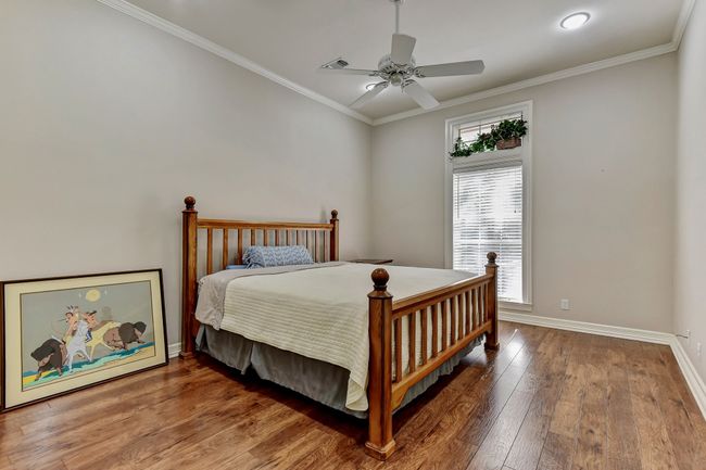 Bedroom with baseboards, crown molding, hardwood / wood-style flooring, and a ceiling fan | Image 20