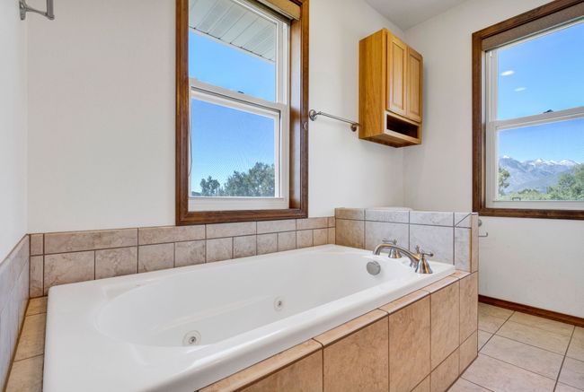 Bathroom featuring plenty of natural light, a jetted tub, and tile patterned flooring | Image 37