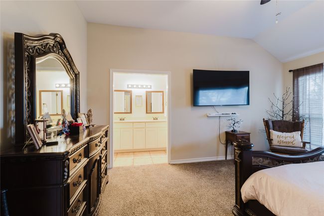 Carpeted bedroom with connected bathroom, sink, and lofted ceiling | Image 8