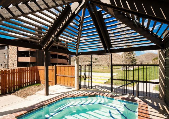 View of swimming pool featuring a pergola, a mountain view, a lawn, and a patio area | Image 23