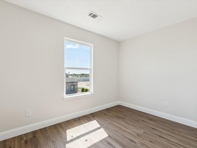 Empty room with wood finished floors, visible vents, and baseboards | Image 22