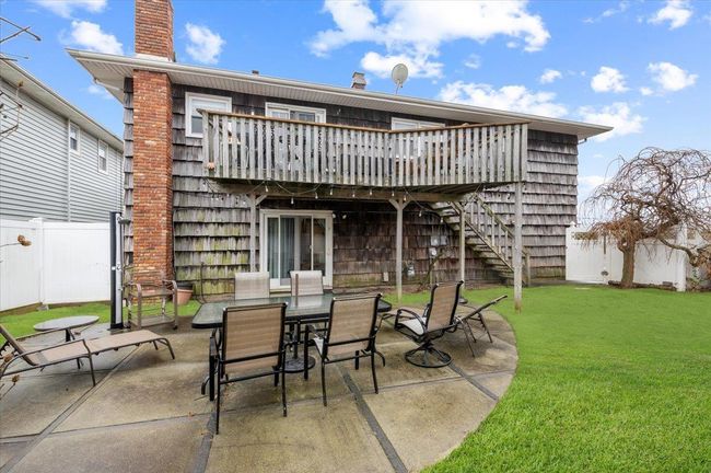 View of patio with a deck, outdoor dining area, a fenced backyard, and stairs | Image 26