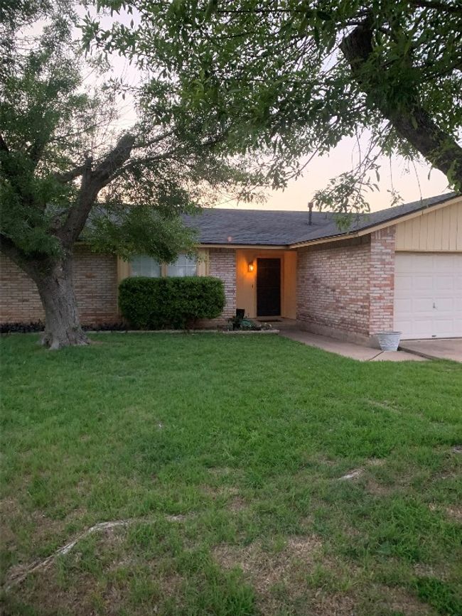 Ranch-style house with an attached garage, a front yard, and brick siding | Image 4