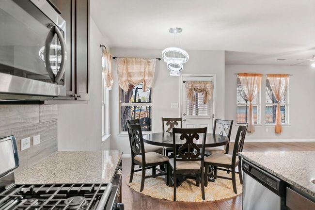 Dining room featuring dark wood-type flooring, an inviting chandelier, and plenty of natural light | Image 21