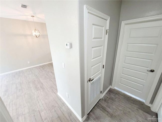 Hallway featuring wood finished floors, visible vents, baseboards, and an inviting chandelier | Image 10