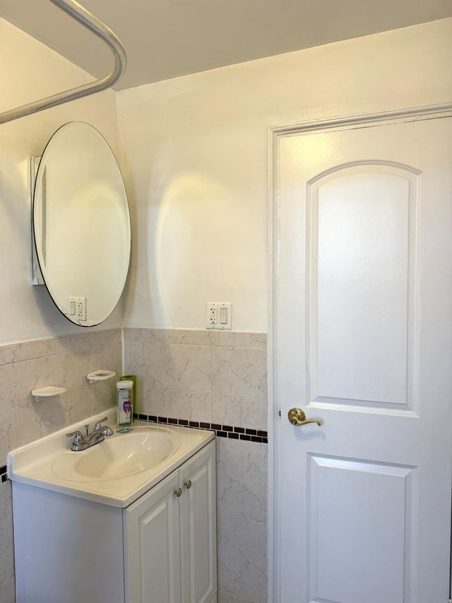 Bathroom featuring tile walls, vanity, and wainscoting | Image 20