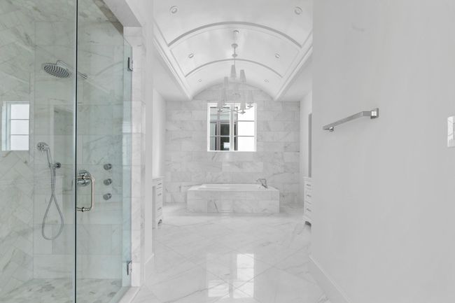 The standout features of the primary spa-suite include extensive marble cladding and a stunning barrel vault ceiling with designer chandelier. | Image 22