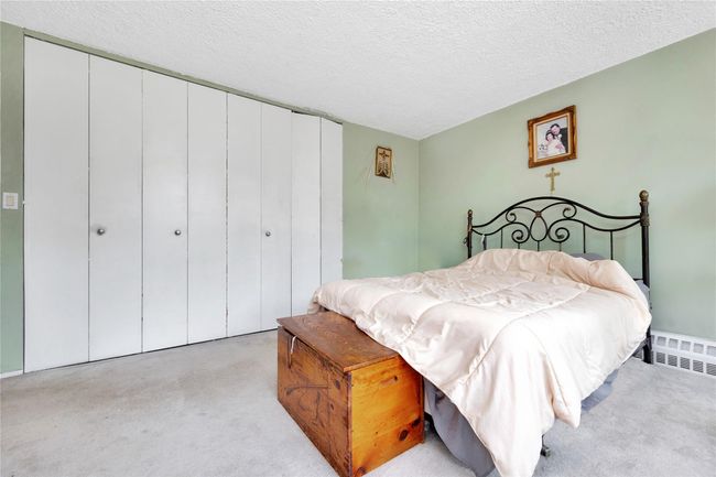 Bedroom featuring carpet flooring, a closet, and a textured ceiling | Image 7
