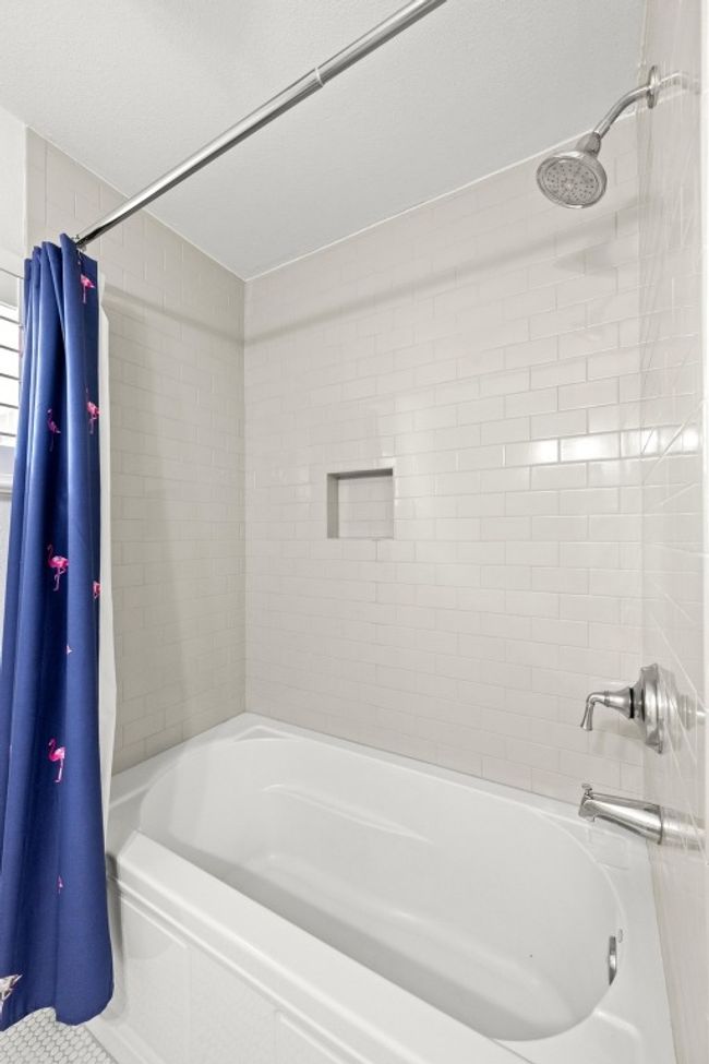 The shower/tub combo is tiled to the ceiling. | Image 16