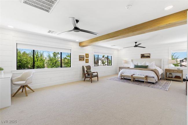 Bedroom featuring wooden walls, visible vents, and multiple windows | Image 23