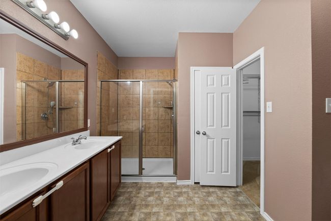 Full bath featuring a sink, double vanity, and a stall shower | Image 9