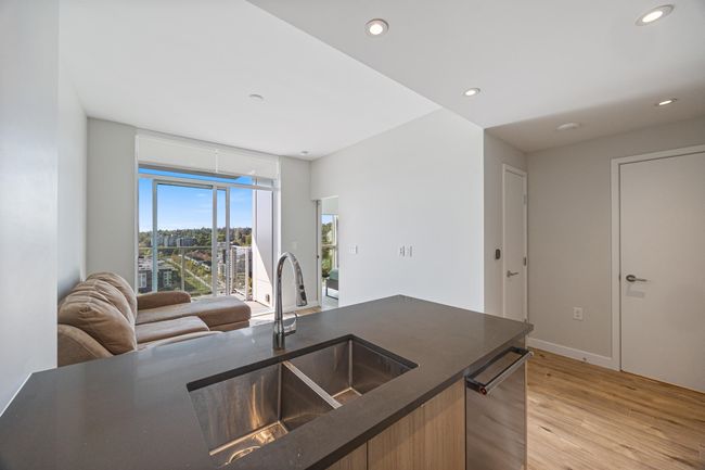 Kitchen with dark countertops, recessed lighting, open floor plan, and light wood-type flooring | Image 7