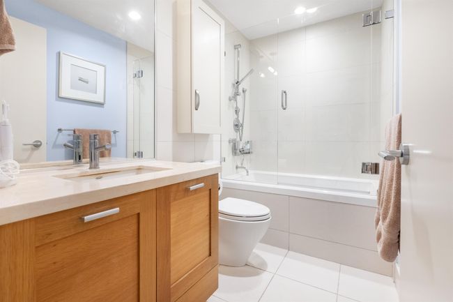 Full bath featuring vanity, enclosed tub / shower combo, toilet, tile patterned flooring, and recessed lighting | Image 9