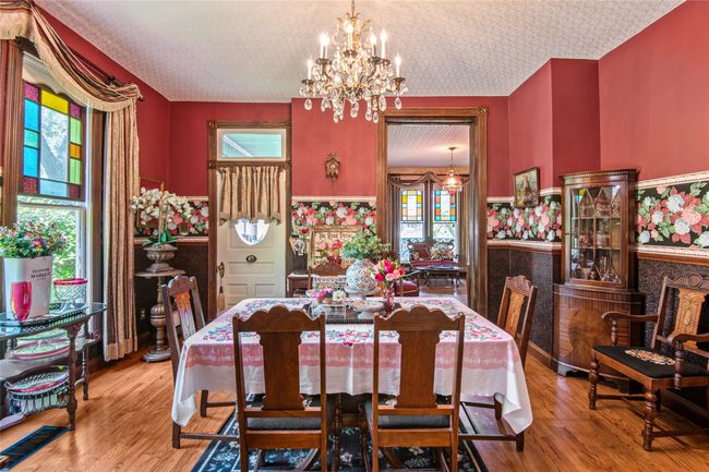 Dining space featuring a wealth of natural light, a notable chandelier, and wood finished floors | Image 8