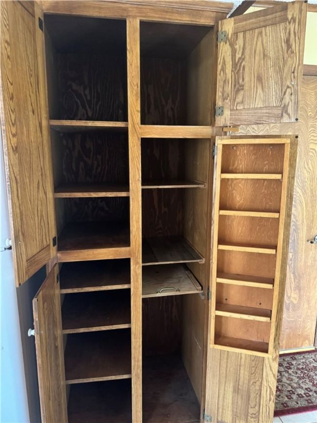 pantry area next to refrigerator | Image 18