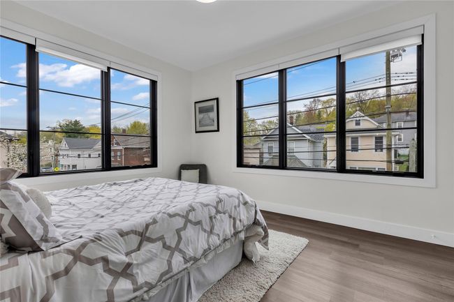Bedroom featuring multiple windows, baseboards, and wood finished floors | Image 19