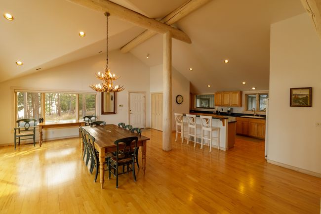 Dining area with light wood-type flooring, high vaulted ceiling, beamed ceiling, sink, and a chandelier | Image 26