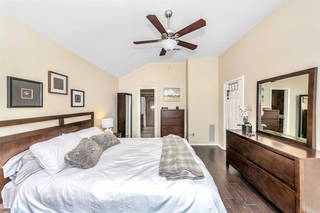 Bedroom with vaulted ceiling, dark wood finished floors, baseboards, and a ceiling fan | Image 20