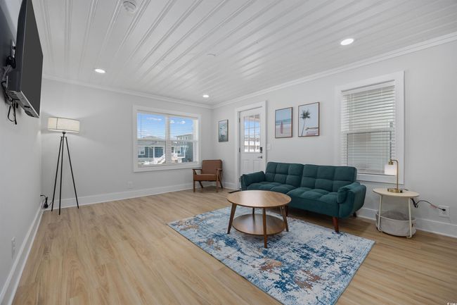 Living area featuring crown molding, baseboards, light wood finished floors, and recessed lighting | Image 23