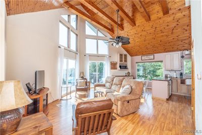 Living room with light wood-type flooring, high vaulted ceiling, and ceiling fan | Image 3