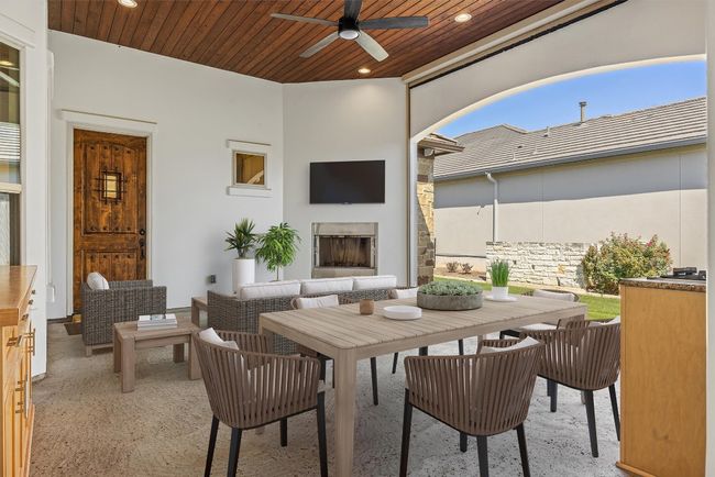 Virtually staged. View of patio / terrace featuring outdoor dining space, a ceiling fan, and an outdoor living space with a fireplace. Perfect place to host football watch parties! | Image 6