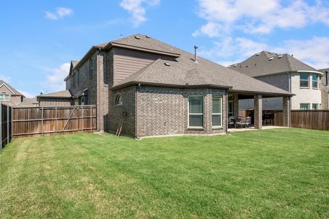 Back of property with a patio, brick siding, a fenced backyard, and roof with shingles | Image 37