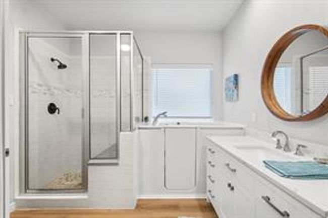 Bathroom with a bath, a stall shower, vanity, and wood finished floors | Image 9