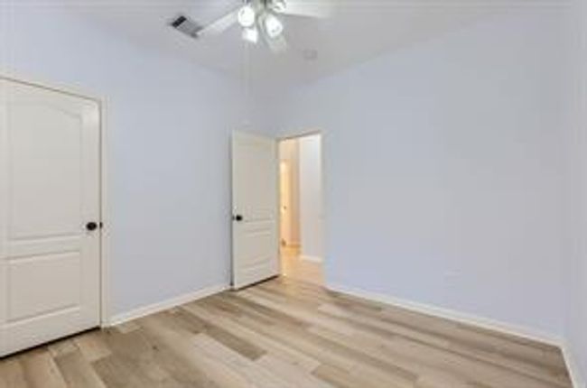 Unfurnished bedroom with light wood-style floors and a ceiling fan | Image 23