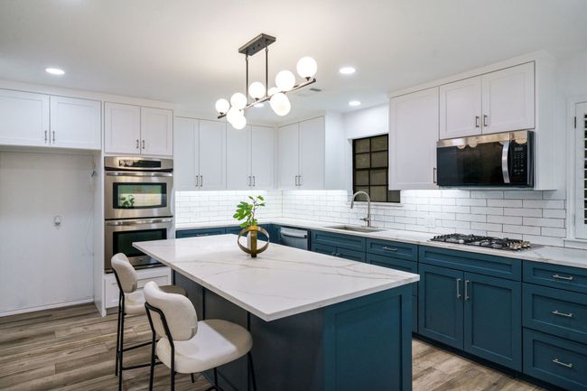 Kitchen with blue cabinets, decorative backsplash, white cabinetry, and recessed lighting | Image 13
