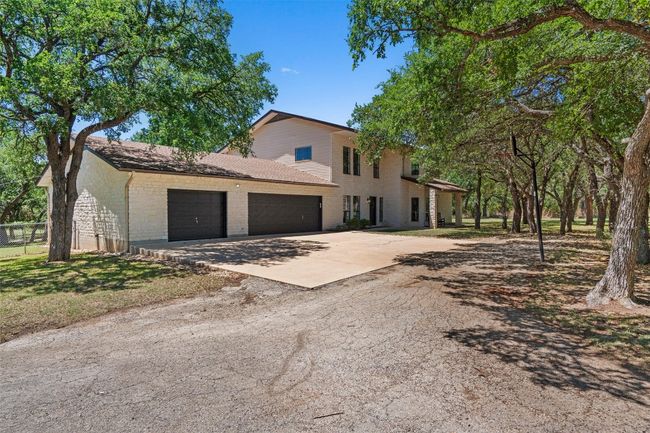 View of front of property featuring an attached garage, brick siding, and concrete driveway | Image 4