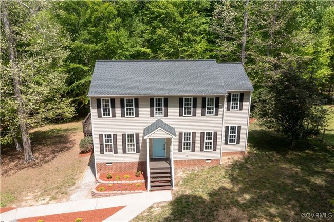 View of front of home featuring a forest view, crawl space, driveway, and a shingled roof | Image 4