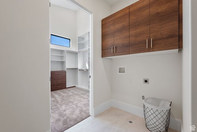 Laundry room with cabinet space, washer hookup, electric dryer hookup, and light colored carpet | Image 46