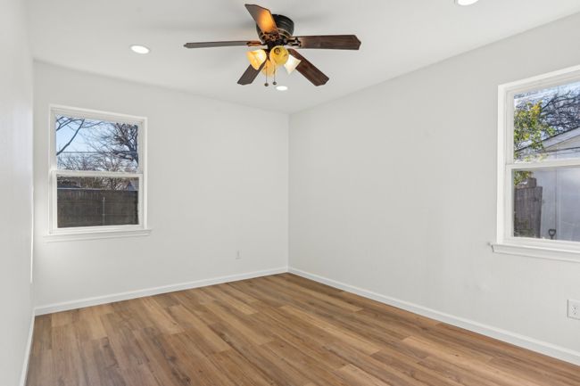 Empty room featuring healthy amount of natural light, wood finished floors, recessed lighting, baseboards, and a ceiling fan | Image 13