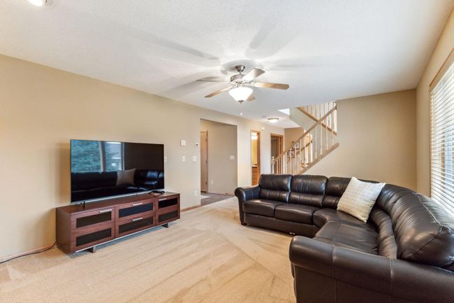 The staircase in this home is centrally located and the stairs going both up and down have a center landing each with a window allowing more light into this home. | Image 8