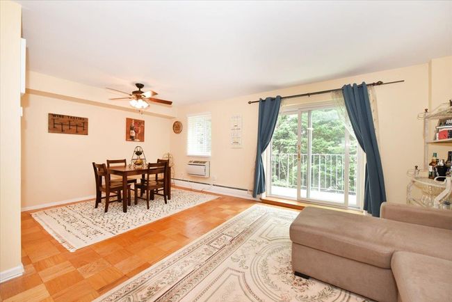 Dining space featuring a ceiling fan, a baseboard heating unit, and an AC wall unit | Image 12