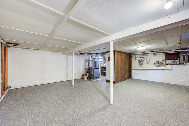 Basement with carpet floors and a heating unit | Image 37