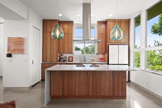 Armani Brazillian quartzite with hidden outlets, dual appliance garages and artesian oak custom cabinetry. | Image 9