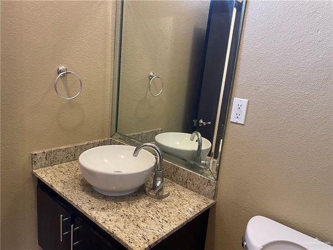 Bathroom with a textured wall, toilet, and vanity | Image 21