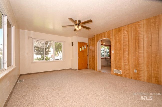 Carpeted spare room featuring arched walkways, a ceiling fan, and a textured ceiling | Image 18