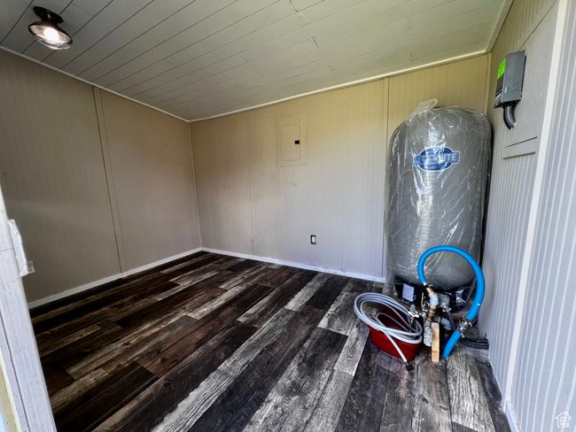 Unfurnished room featuring wood finished floors, baseboards, electric panel, and wooden ceiling | Image 46