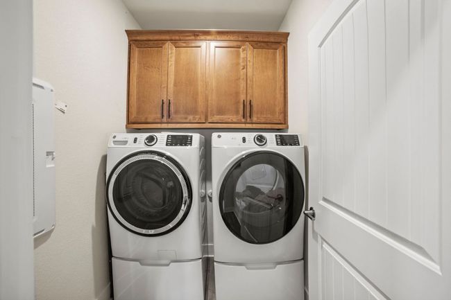 Clothes washing area featuring washing machine and clothes dryer and cabinet space | Image 20